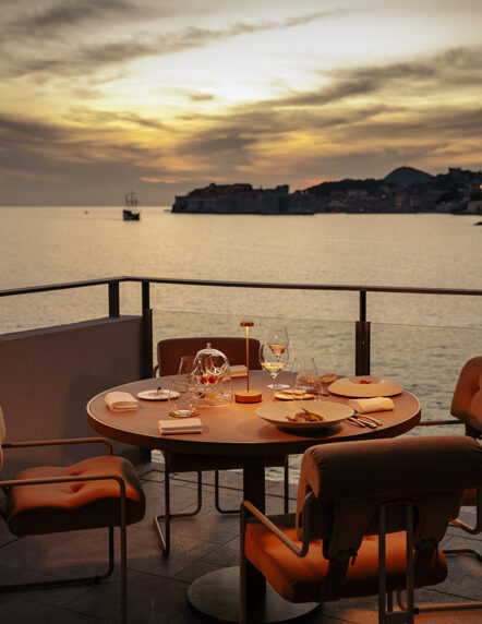 Dinner table set on the Pjerin terrace at sunset, overlooking the Adriatic